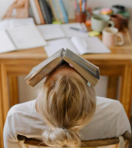 Woman looking unsure while holding a book, symbolizing didn't like the book club pick